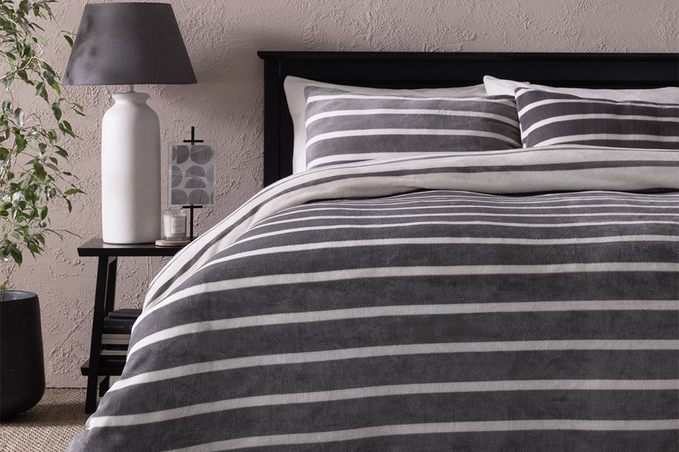 A bed covered with Argos Home fleece stripe printed bedding set.